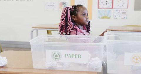 Young african american girl learning about recycling in classroom