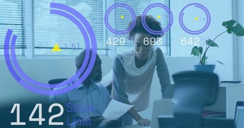 Black professionals collaborating over analytics dashboard and reports in modern office