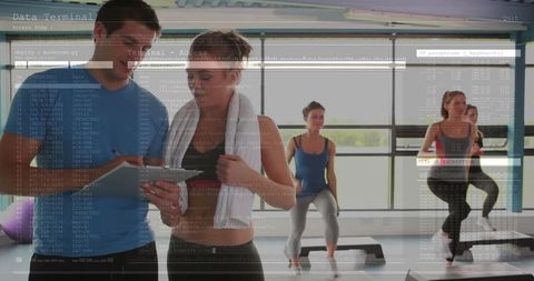 Instructor coaching fitness class with tablet technology overlay
