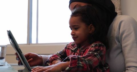Mother and Daughter Using Tablet in Kitchen, Cozy Togetherness