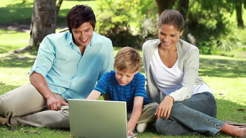 Happy Family Enjoying Technology in Park Setting
