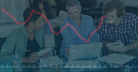 Diverse team analyzing financial trends with laptop during meeting