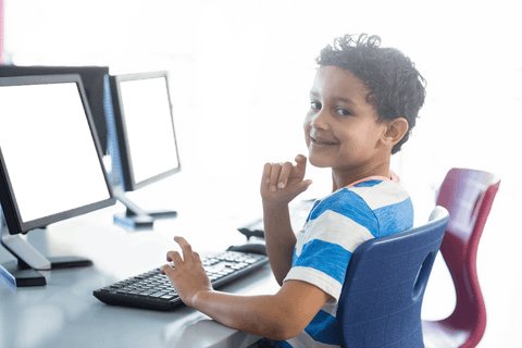 smiling boy using computer in classroom with transparent monitor - Download Free Stock Videos Pikwizard.com