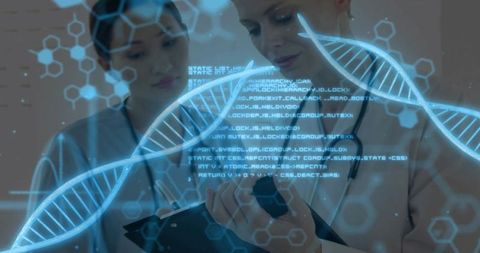 Two female clinicians consulting on tablet with holographic dna helix and clinical data