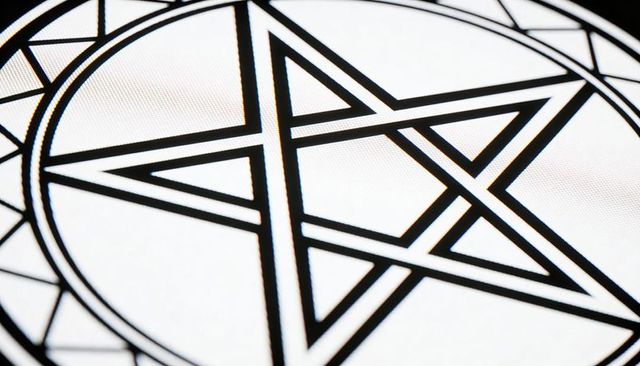 Bold black hexagram emblem on textured white canvas with circular geometric border and rim motif