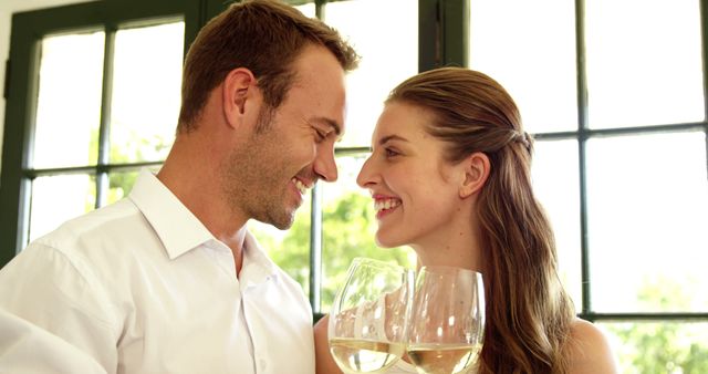 Couple toasting with white wine in restaurant