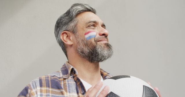 Smiling Man Holding Soccer Ball with Painted Cheek for Team Spirit - Download Free Stock Images Pikwizard.com