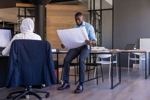 Diverse Coworkers in Office Analyzing Blueprint