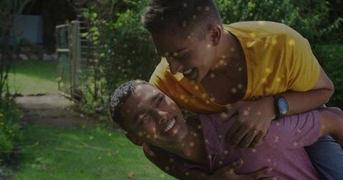 Friends Piggyback Ride Outdoors in Lush Garden