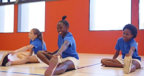 Diverse Girls Stretching Together in Gym Promoting Healthy Lifestyle