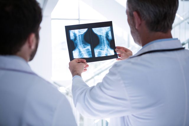 Doctors having discussion on x-ray report in corridor - Download Free Stock Photos Pikwizard.com