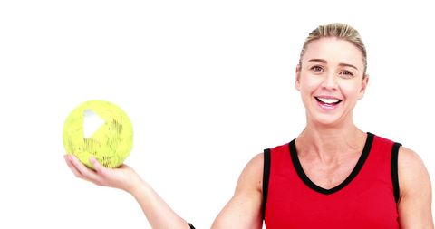 Energetic female athlete holding handball smiling