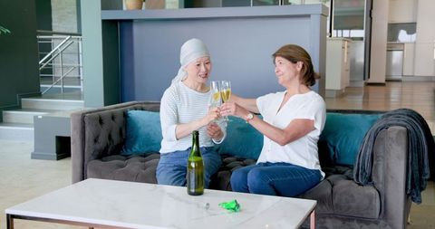 Senior Women Celebrating Friendship with Champagne Indoors