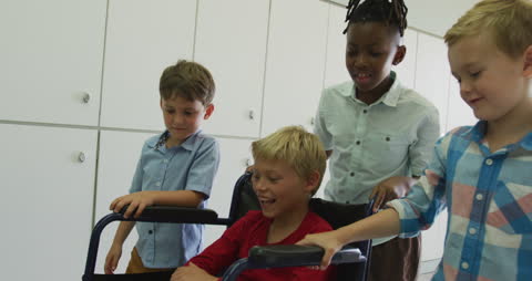 Happy Boy in Wheelchair with Friends at School