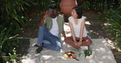 Couple Enjoying Picnic with Fresh Fruits Outdoors