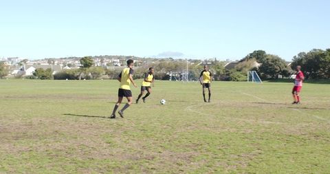 Soccer Team Practicing on Pitch with Clear Skies