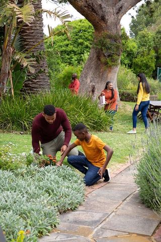 Family Enjoying Park Day Bonding Through Gardening Activities