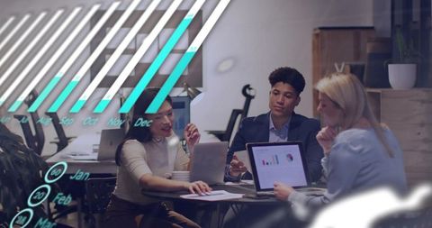 Team Reviewing Charts in Modern Office Meeting with Laptops and Data Visualization