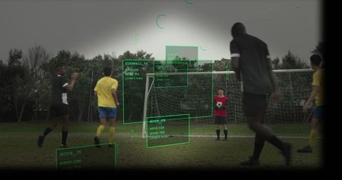 Youth goalkeeper holding soccer ball while augmented reality hud overlays tactical data