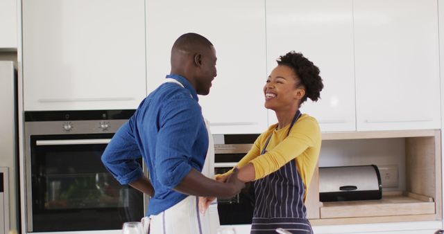 Image of happy african american couple dancing in kitchen. Love, relationship and spending quality time together concept.