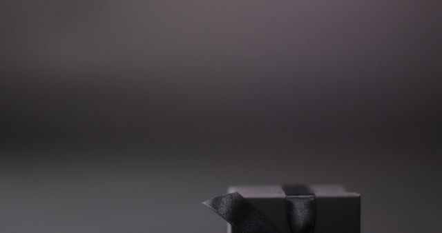 Black gift box with black ribbon on dark grey background with copy space - Download Free Stock Photos Pikwizard.com