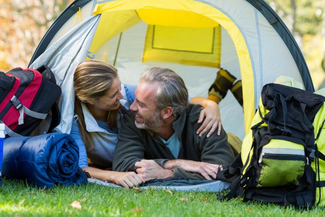 Couple enjoying a moment together inside a tent during a camping trip. Ideal for promoting outdoor activities, travel, adventure, and lifestyle content. Perfect for use in advertisements, blogs, and social media posts related to camping, hiking, and nature exploration.