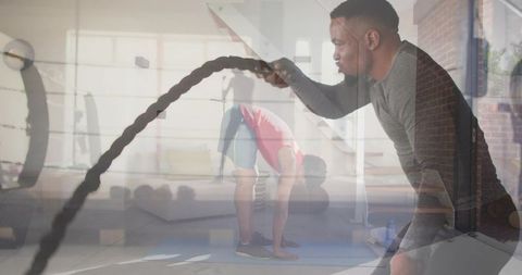 Man training with battle ropes double exposure gym concept for cardio and strength
