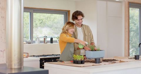 Friends enjoying indoor gardening and plant care in cozy kitchen