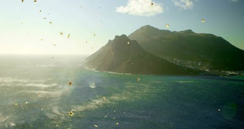 Golden sparkles over rugged coastal seascape