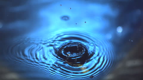 Olives on Cocktail Stick Splashing into Water in Slow Motion