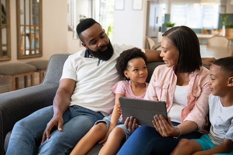 Family Bonding Time with Tablet in Cozy Living Room Setting