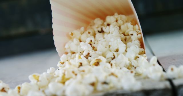 A close-up view of popcorn spilling out of a container, with copy space - Download Free Stock Photos Pikwizard.com