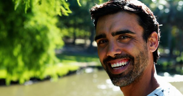 Smiling Man Enjoying Sunny Day Outdoors by River - Download Free Stock Images Pikwizard.com