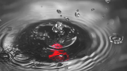 Close-up of Red Cylinder Creating Ripples in Water