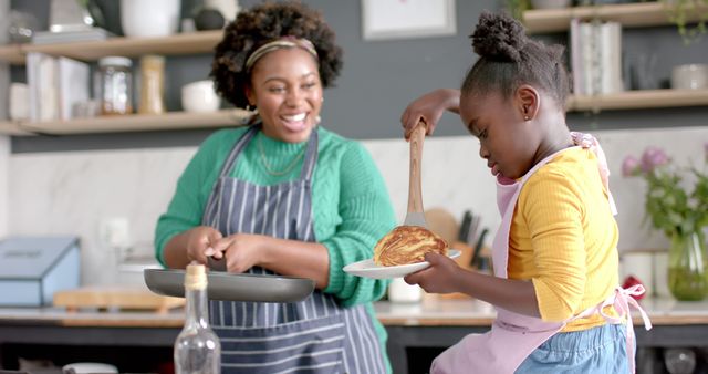 This image is ideal for use in articles, websites, and advertisements focusing on family life, cooking with kids, and parent-child bonding activities. It visually represents themes of teaching, learning, home cooking, and the joys of spending time together. It can be useful in promoting kitchen products, family-oriented services, and educational content.