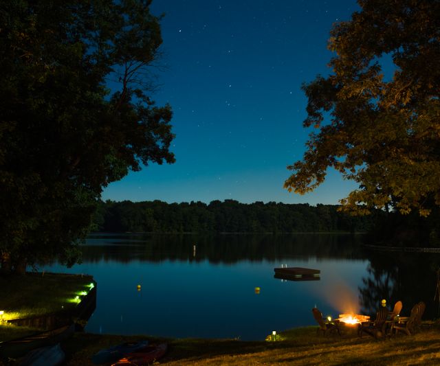 Serene Lakeside Night with Bonfire and Starry Sky Reflection - Download Free Stock Photos Pikwizard.com