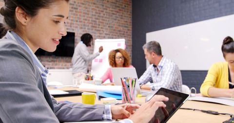 Businesswoman Using Tablet in Collaborative Meeting Room