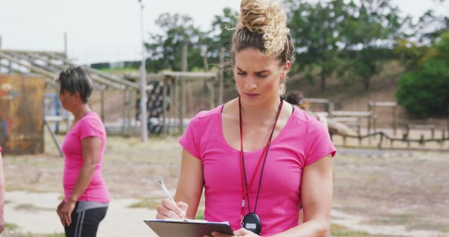 Female Instructor Taking Notes During Outdoor Training Session - Download Free Stock Images Pikwizard.com