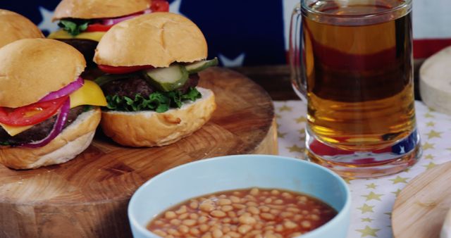 Close up of burgers, baked beans and glass of beer on stars of flag of united states of america. Independence day, 4th of july, american patriotism, celebration and tradition concept.
