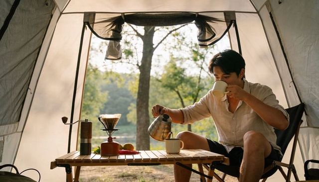 Morning coffee ritual in tent pouring gooseneck kettle camping lifestyle outdoors
