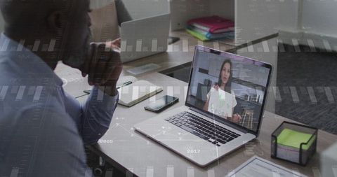 Businessman engaged in virtual meeting with remote colleague on laptop