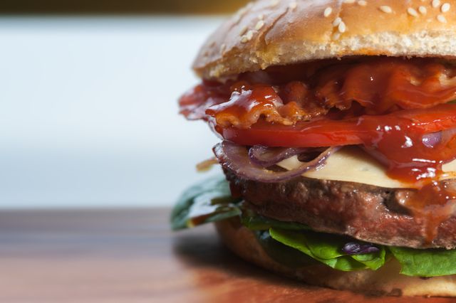 Close-Up of Juicy Hamburger with Bacon, Cheese, Lettuce and Tomato - Download Free Stock Photos Pikwizard.com
