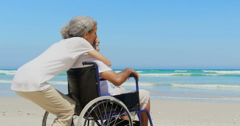 Senior Couple Enjoying Beach Together in Wheelchair