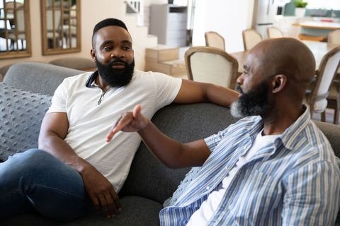 Friends Relaxing and Conversing on Comfortable Living Room Sofa