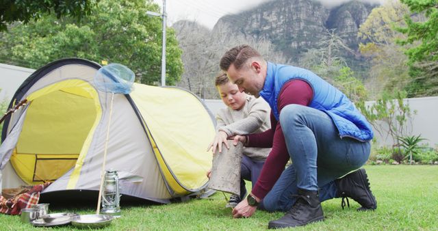 Father and son setting up camp in backyard with mountainous background - Download Free Stock Images Pikwizard.com