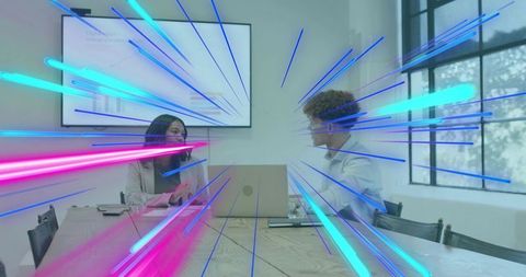 Colleagues collaborating in boardroom while neon light streaks energizing presentation