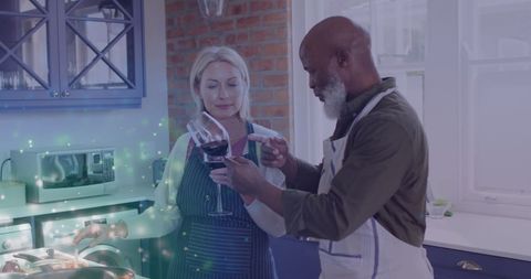 Diverse Senior Couple Enjoying Wine Together in Kitchen