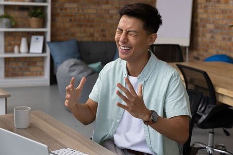 Cheerful asian man working in sophisticated office setting