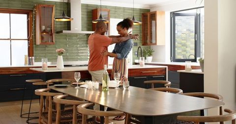 Couple Embracing in Modern Kitchen with Dining Table