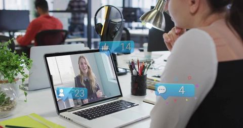 Office employee engaged in a video conference call at desk